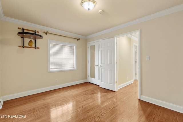 unfurnished bedroom featuring baseboards, light wood-style flooring, and crown molding