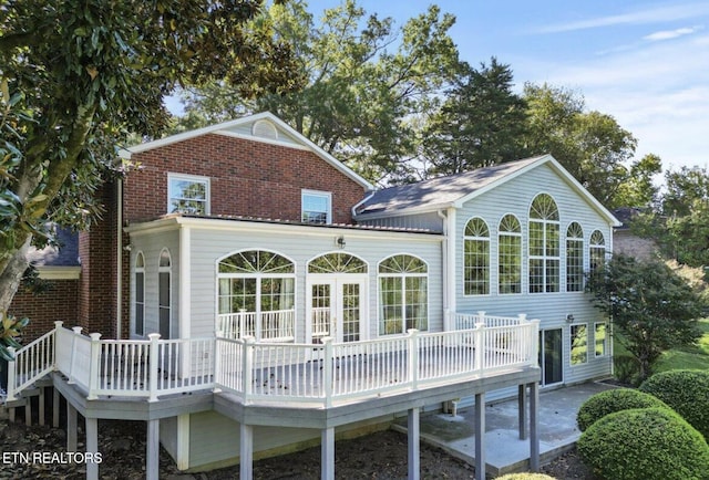 rear view of property with brick siding and a wooden deck