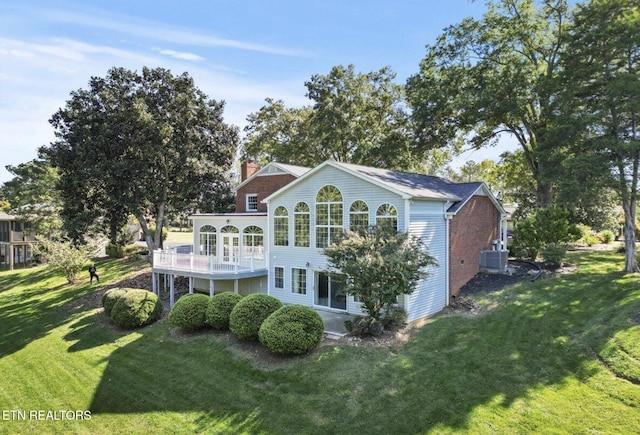 back of house featuring a deck, cooling unit, a lawn, and a chimney