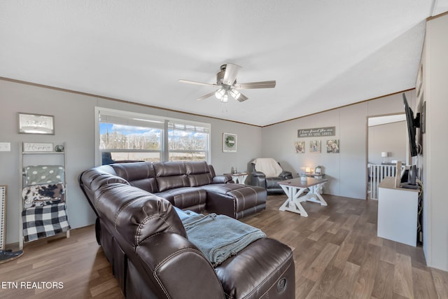 living room with ornamental molding, vaulted ceiling, hardwood / wood-style floors, and ceiling fan