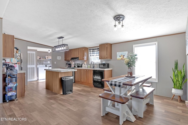 kitchen with sink, light hardwood / wood-style flooring, independent washer and dryer, wine cooler, and decorative light fixtures