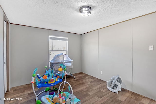 game room with hardwood / wood-style flooring and a textured ceiling