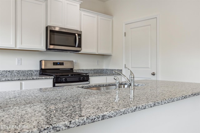 12468 Hatmaker Ln, Knoxville, TN 37932 - kitchen featuring stainless steel appliances, a sink, white cabinets, and light stone counters