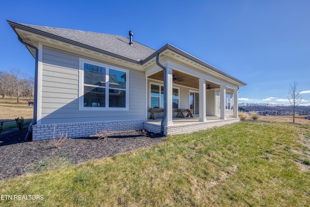 back of house with a lawn, ceiling fan, and a porch