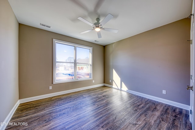 spare room featuring ceiling fan and dark hardwood / wood-style flooring