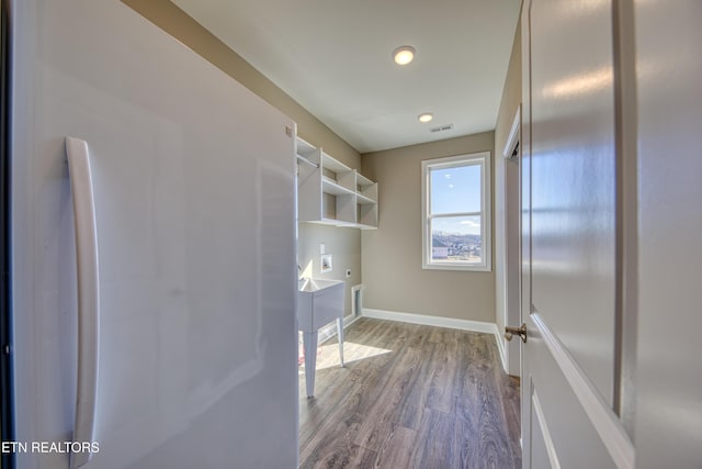 laundry area with electric dryer hookup, hookup for a washing machine, and light hardwood / wood-style flooring