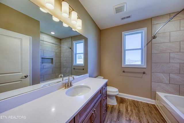 full bathroom featuring tiled shower / bath combo, wood-type flooring, vanity, and toilet