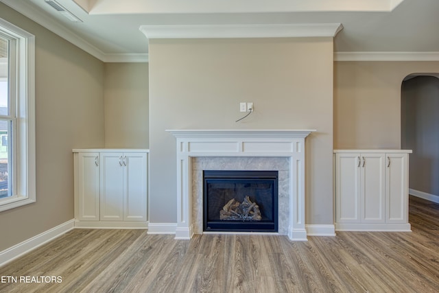 interior details with a premium fireplace, ornamental molding, and hardwood / wood-style floors