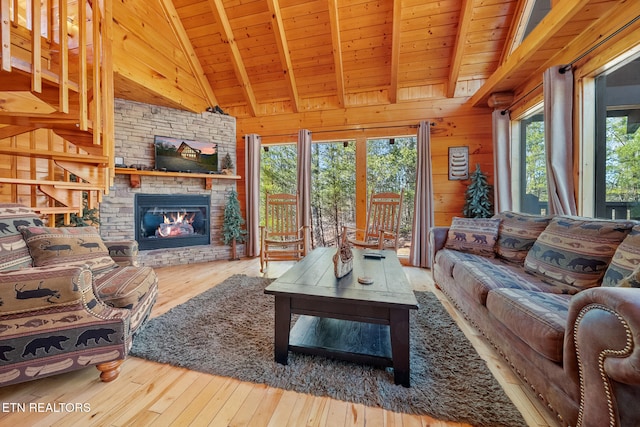 living room featuring vaulted ceiling with beams, wood ceiling, wooden walls, and hardwood / wood-style flooring