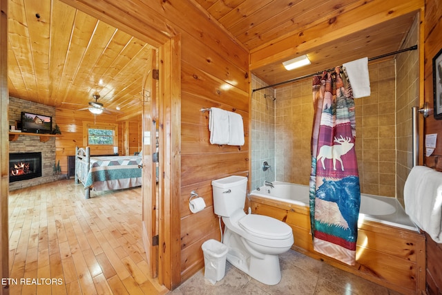 bathroom with wooden walls, a fireplace, shower / bath combination with curtain, toilet, and wooden ceiling