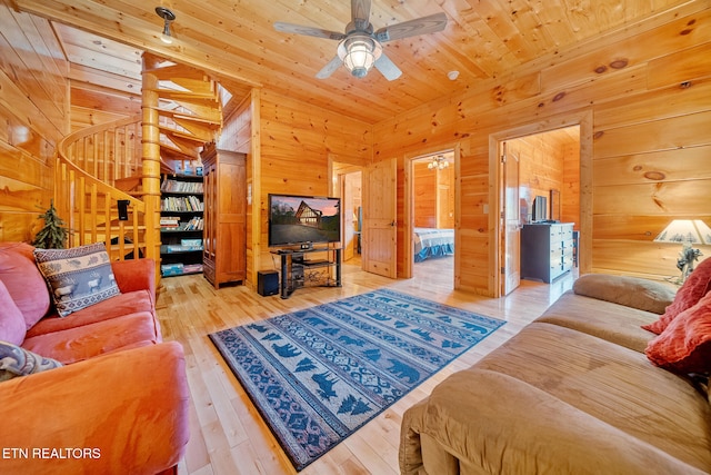 living room with hardwood / wood-style flooring, wooden ceiling, ceiling fan, and wood walls