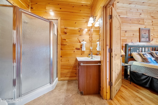 bathroom with vanity, hardwood / wood-style floors, wooden walls, and walk in shower