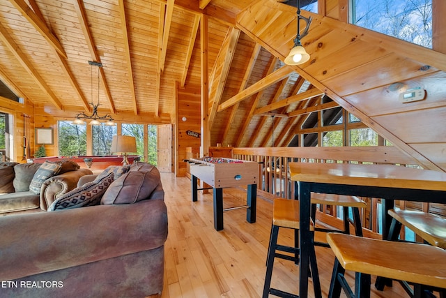 living room with wood ceiling, wooden walls, light hardwood / wood-style flooring, and vaulted ceiling with beams