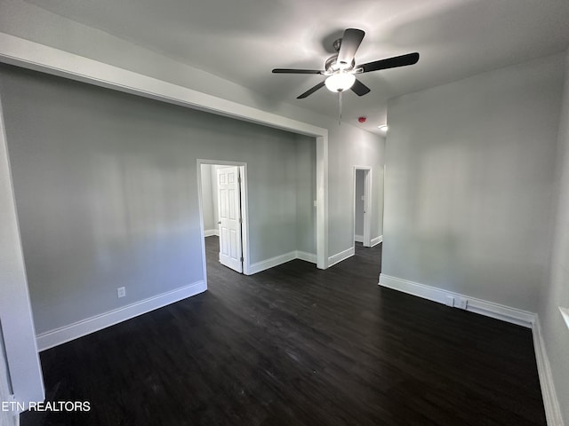 empty room with dark hardwood / wood-style floors and ceiling fan