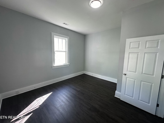 spare room with dark wood-type flooring