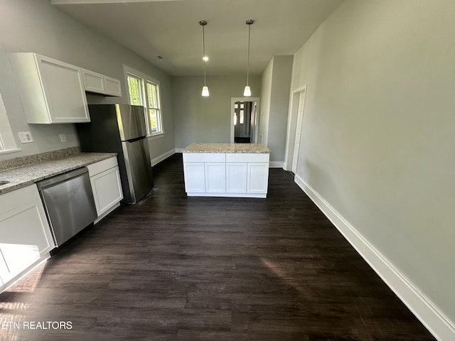 kitchen featuring appliances with stainless steel finishes, white cabinetry, hanging light fixtures, light stone counters, and a kitchen island