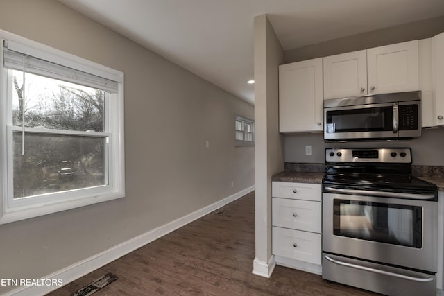 kitchen featuring white cabinetry, appliances with stainless steel finishes, and dark hardwood / wood-style floors