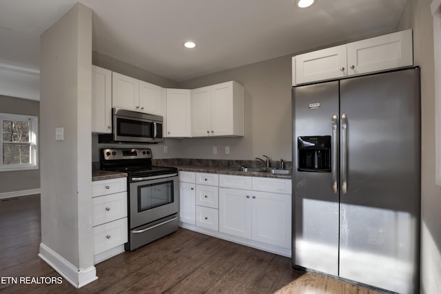 kitchen featuring stainless steel appliances, sink, dark wood-type flooring, and white cabinets