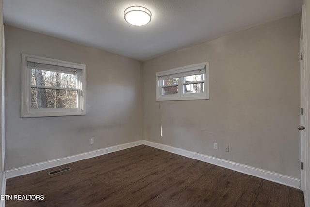 unfurnished room with dark wood-type flooring