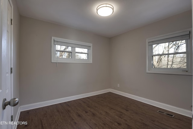 unfurnished room featuring dark hardwood / wood-style floors and a wealth of natural light