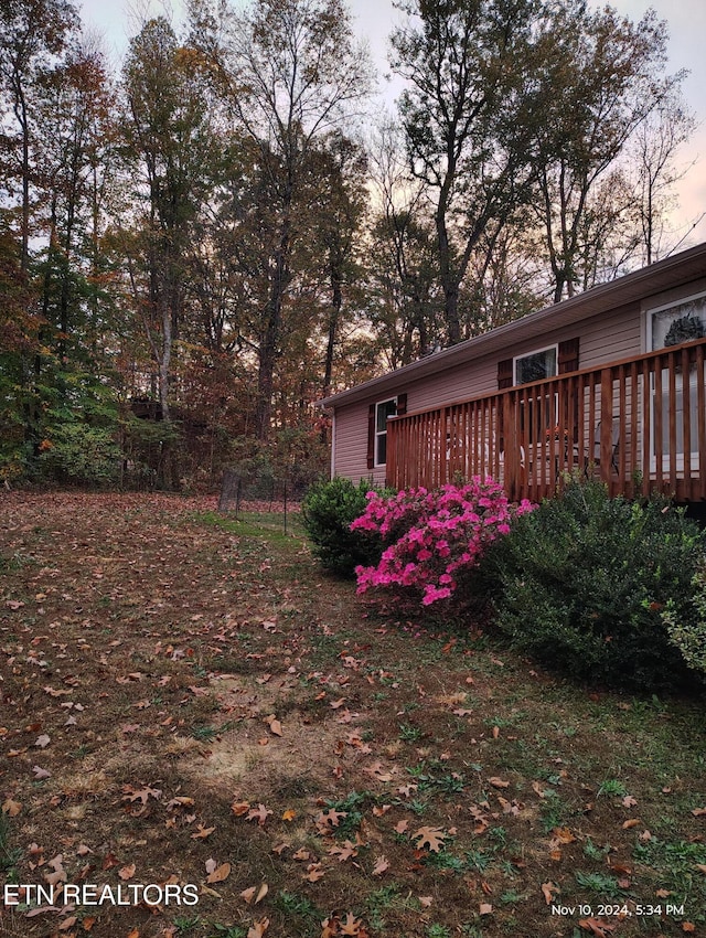 yard at dusk featuring a deck