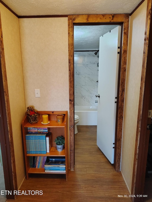 hall featuring hardwood / wood-style floors and a textured ceiling