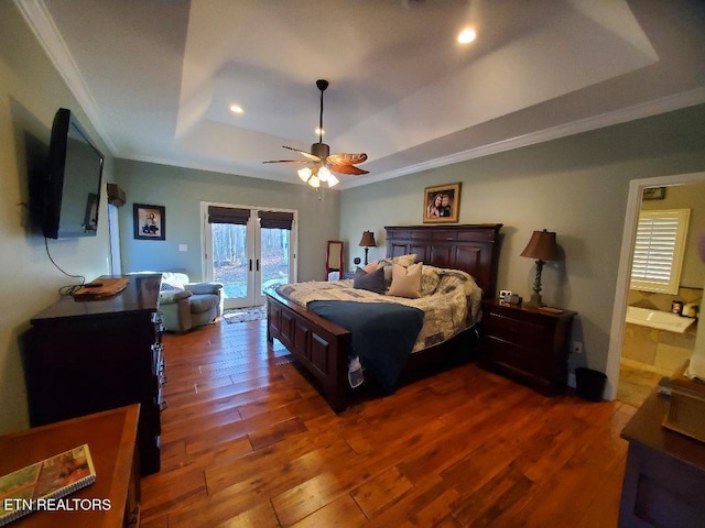 bedroom with dark hardwood / wood-style floors, ornamental molding, access to exterior, a tray ceiling, and french doors