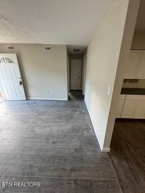 interior space featuring dark hardwood / wood-style flooring and a textured ceiling