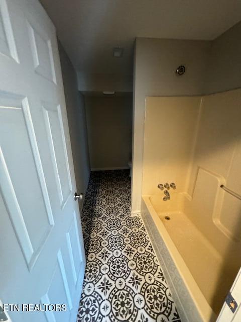 bathroom with walk in shower and tile patterned flooring