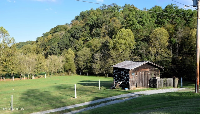 view of property's community with a yard and an outdoor structure