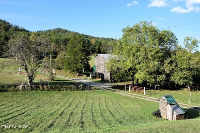 view of community with a lawn and a rural view