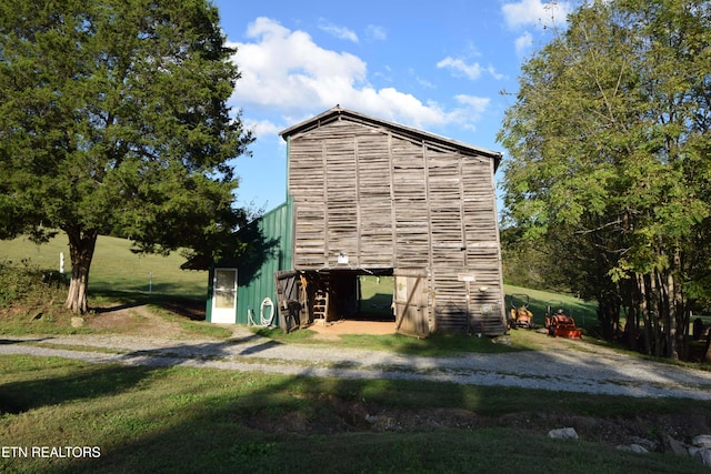 view of side of home featuring an outbuilding and a yard