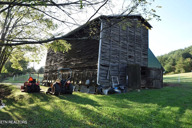 view of home's exterior with an outdoor structure and a yard