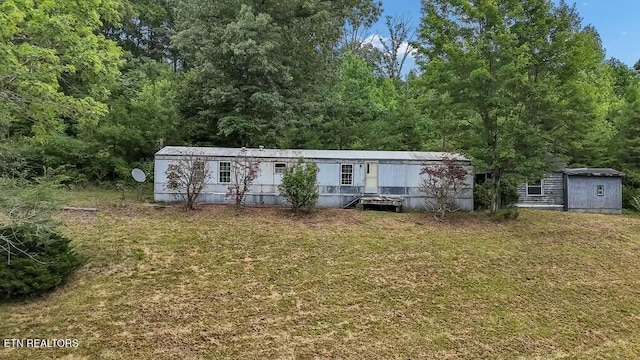 manufactured / mobile home featuring a shed and a front yard