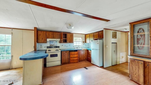 kitchen with backsplash, white appliances, light hardwood / wood-style floors, and kitchen peninsula