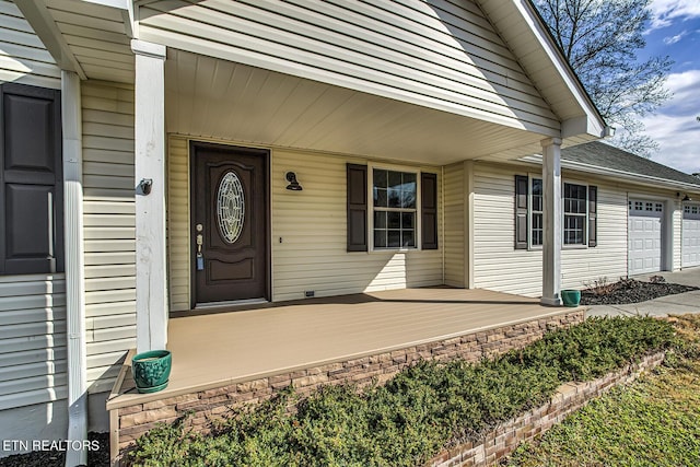 doorway to property with a porch and a garage