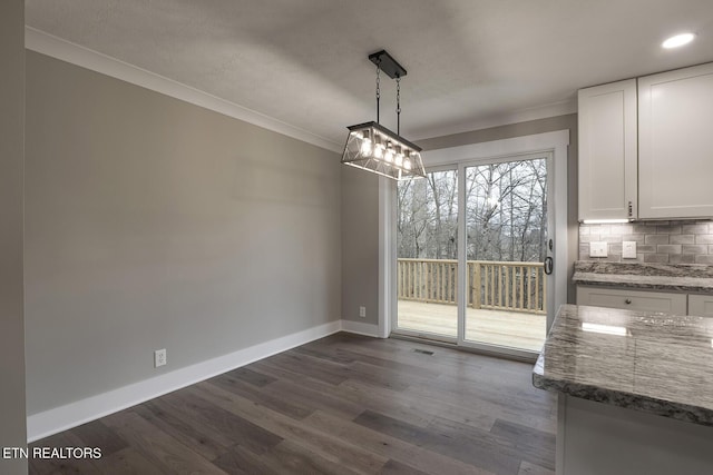 unfurnished dining area featuring crown molding and dark hardwood / wood-style flooring