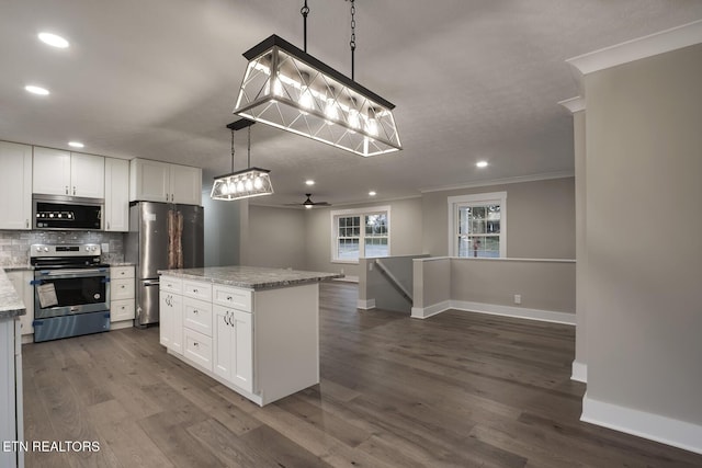 kitchen with a center island, pendant lighting, stainless steel appliances, light stone countertops, and white cabinets