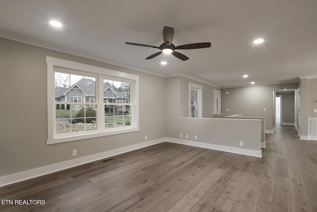 spare room with hardwood / wood-style flooring, ceiling fan, and crown molding