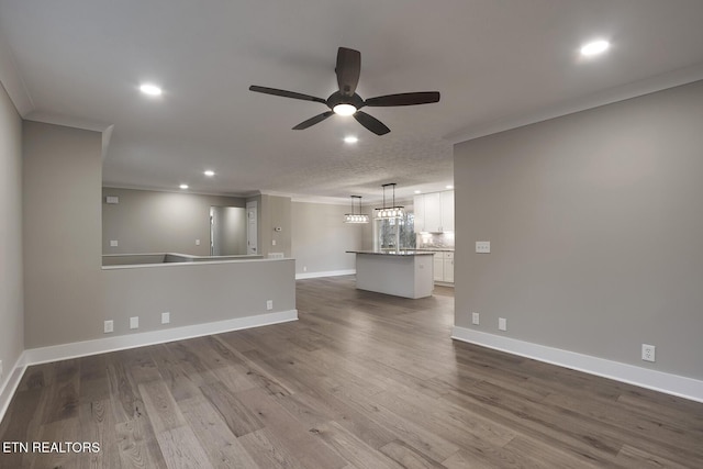 unfurnished living room featuring hardwood / wood-style flooring, ornamental molding, and ceiling fan