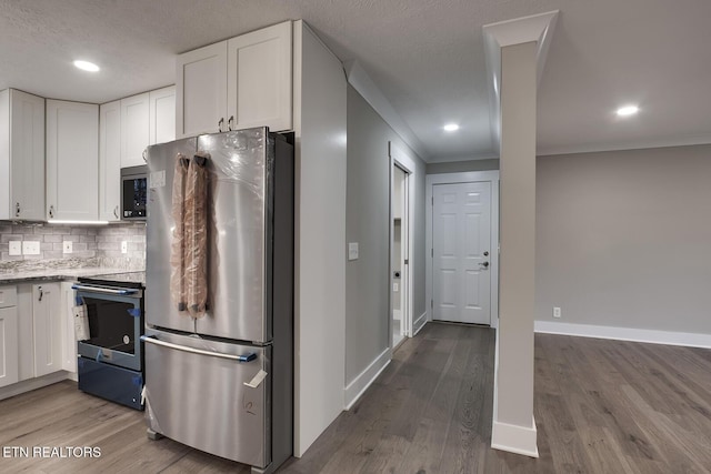 kitchen featuring white cabinetry, backsplash, stainless steel appliances, and light wood-type flooring