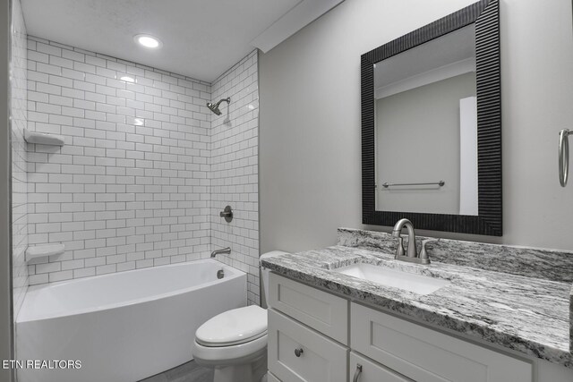 full bathroom with tiled shower / bath combo, vanity, and toilet