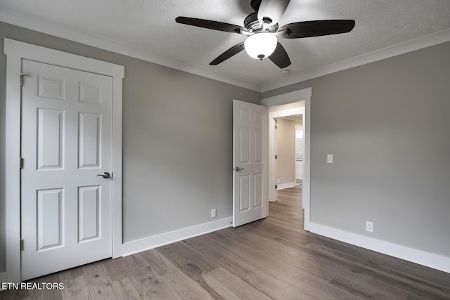 unfurnished bedroom with ornamental molding, ceiling fan, a textured ceiling, and light wood-type flooring