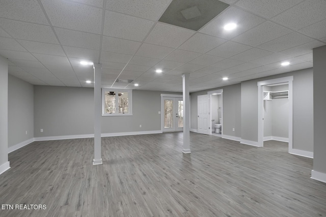 basement featuring hardwood / wood-style flooring and a drop ceiling