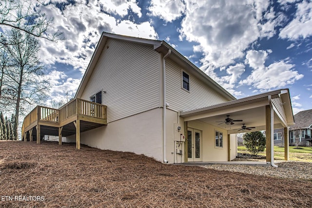 rear view of property with a wooden deck and ceiling fan