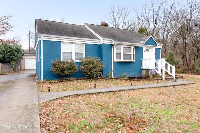 view of front facade featuring an outbuilding, a garage, and a front yard