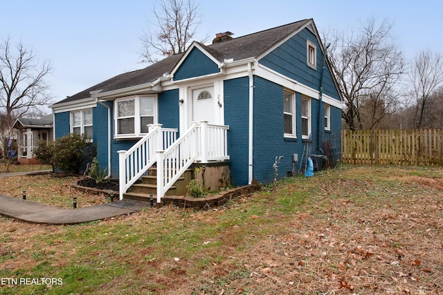 bungalow-style home with a front yard