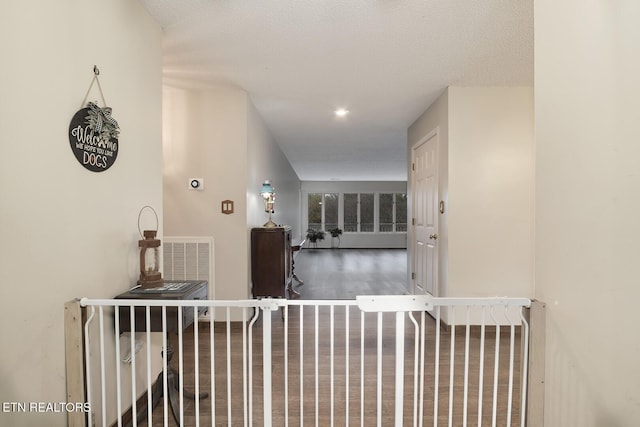 hall with hardwood / wood-style flooring and a textured ceiling