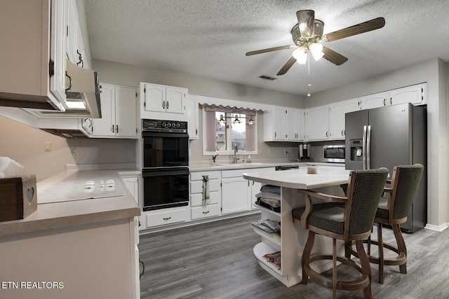 kitchen featuring dark wood-type flooring, sink, a textured ceiling, stainless steel appliances, and white cabinets