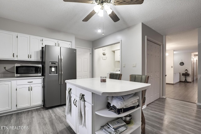 kitchen with white cabinetry, stainless steel appliances, light hardwood / wood-style flooring, and a textured ceiling